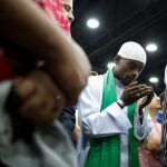 Un hombre asiste a la ceremonia por el rito islámico por la muerte del legendario púgil estadounidense Muhammad Alí en el centro de exposiciones de Kentucky, Louisville