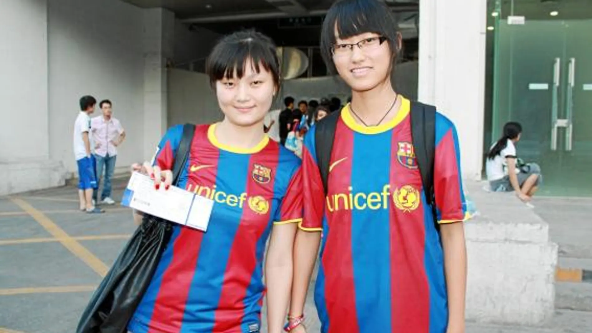 Las dos aficionadas chinas muestran su entrada para el partido de hoy a las puertas del estadio olímpico de Pekín