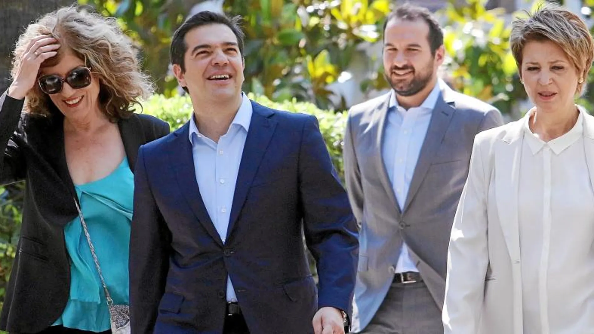 El primer ministro griego, Alexis Tsipras, abandona el palacio presidencial escoltado por varios de los miembros de su gabinete, ayer, en Atenas