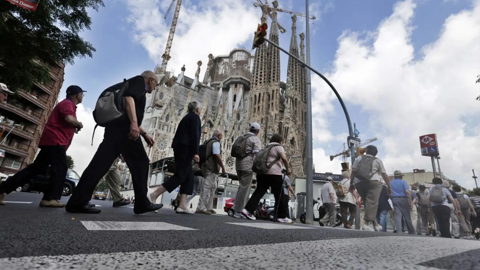 Imagen de archivo de un grupo de turistas llega caminando en las inmediaciones de la basílica de la Sagrada Familia de Barcelona