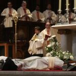 Los tres nuevos sacerdotes se postran durante las letanías de los santos como símbolo de humildad y de pequeñez del hombre ante Dios bajo la atenta mirada del cardenal arzobispo, Ricardo Blázquez