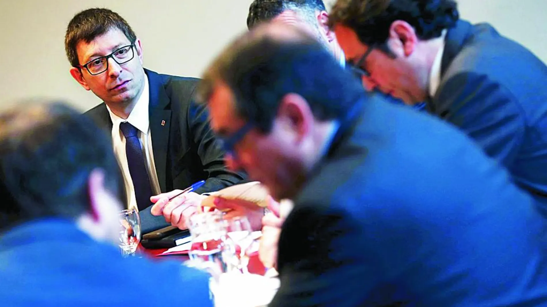 El conseller de Justicia, Carles Mundó, al fondo, y el de Interior, Jordi Jané, difuminado, ayer en la reunión del Govern