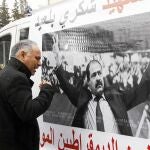 Un hombre llora en Túnez, ayer, ante una pancarta con la foto del lider opositor asesinado