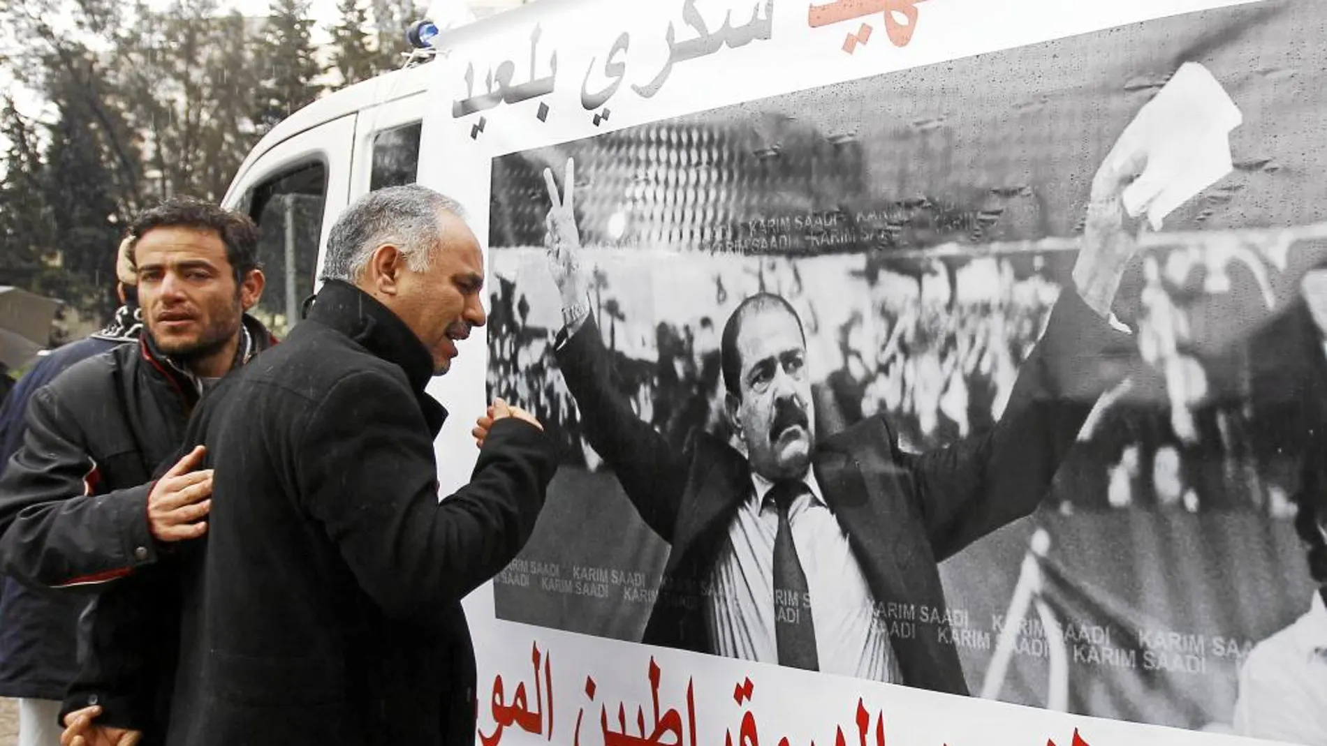 Un hombre llora en Túnez, ayer, ante una pancarta con la foto del lider opositor asesinado