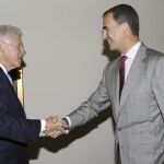 El Rey saluda al expresidente de Estados Unidos Bill Clinton (i) durante el encuentro que mantuvieron ayer en la Fundación Clinton, en Nueva York.