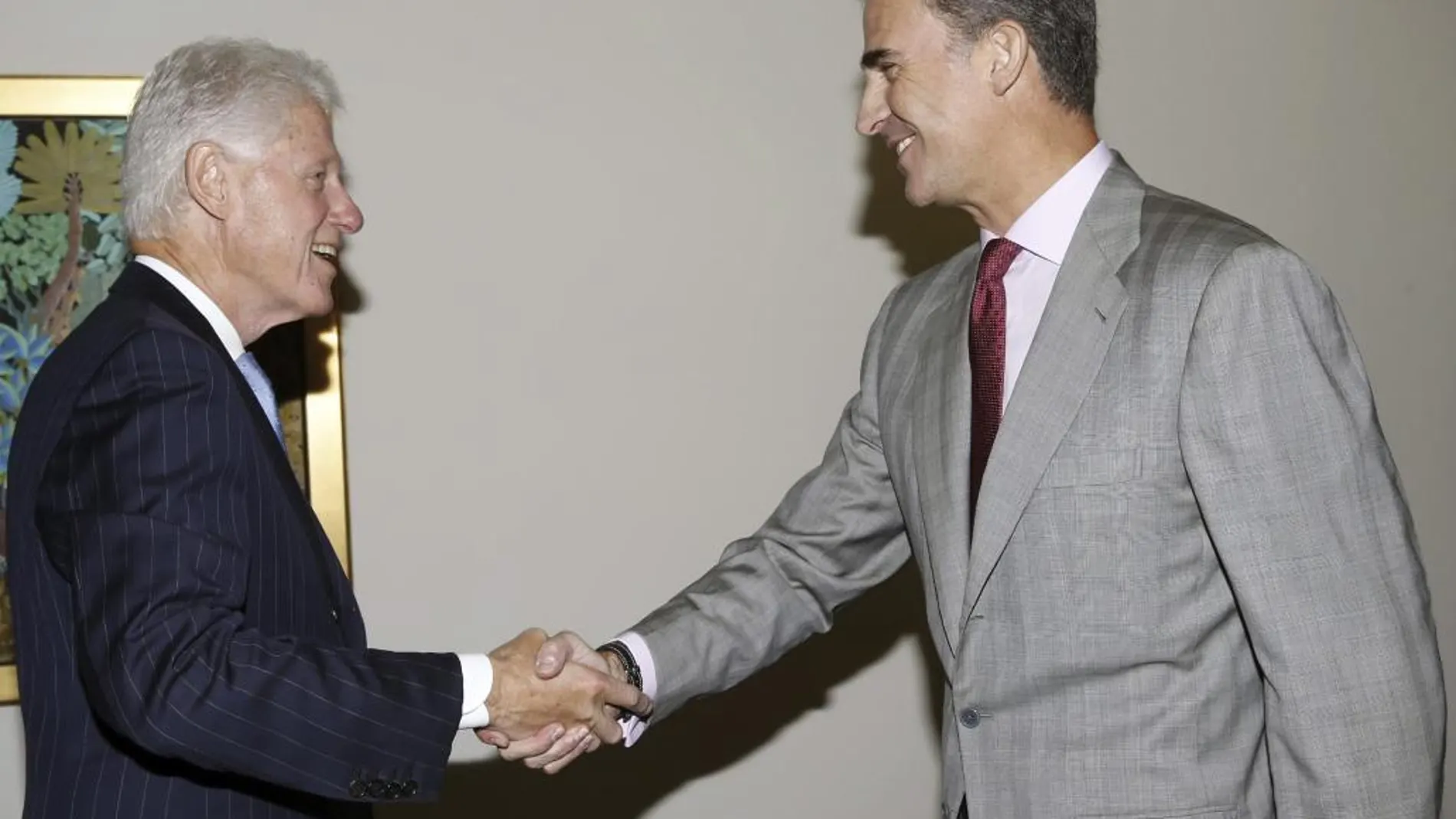 El Rey saluda al expresidente de Estados Unidos Bill Clinton (i) durante el encuentro que mantuvieron ayer en la Fundación Clinton, en Nueva York.