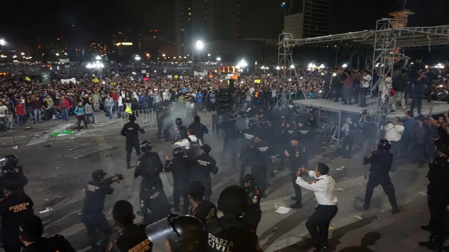 Policías de la ciudad de Monterrey (México), se enfrentan con un tumulto de manifestantes.
