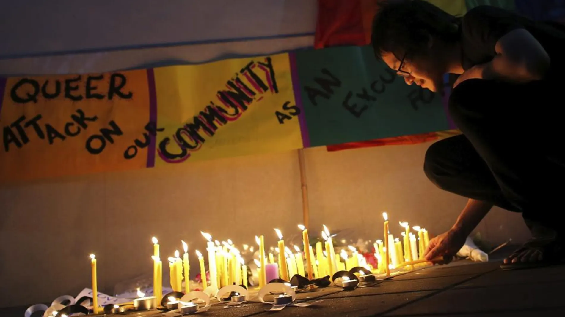 Un hombre enciende una vela en memoria de las victimas del ataque en la discoteca gay en Orlando.