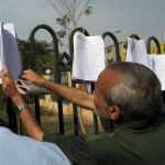 Dos votantes comprueban las listas en las puertas de un colegio electoral