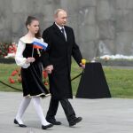 Vladimir Putin, junto a una joven que sostiene una bandera rusa en Yerevan, Armenia