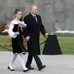Vladimir Putin, junto a una joven que sostiene una bandera rusa en Yerevan, Armenia