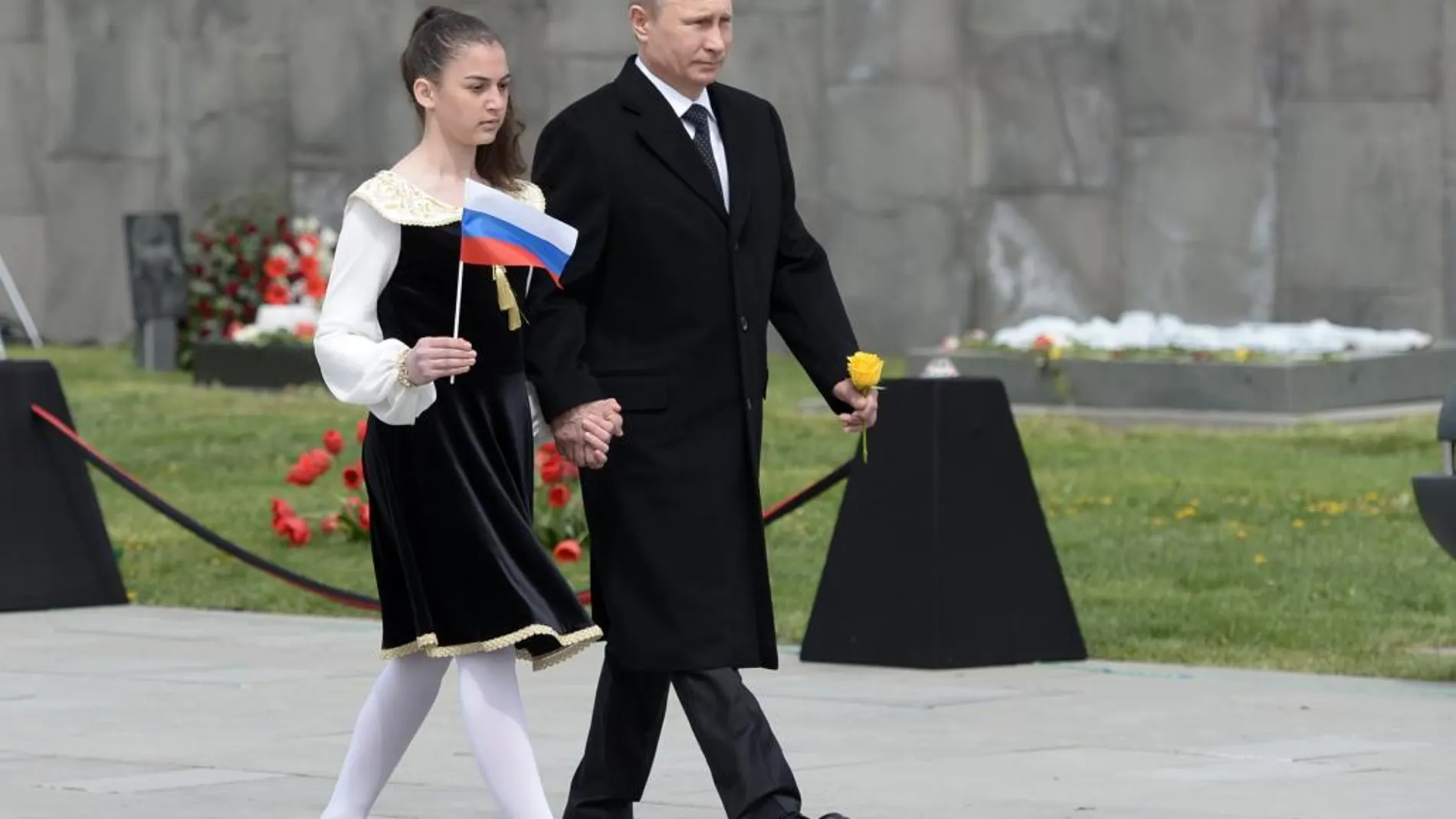 Vladimir Putin, junto a una joven que sostiene una bandera rusa en Yerevan, Armenia