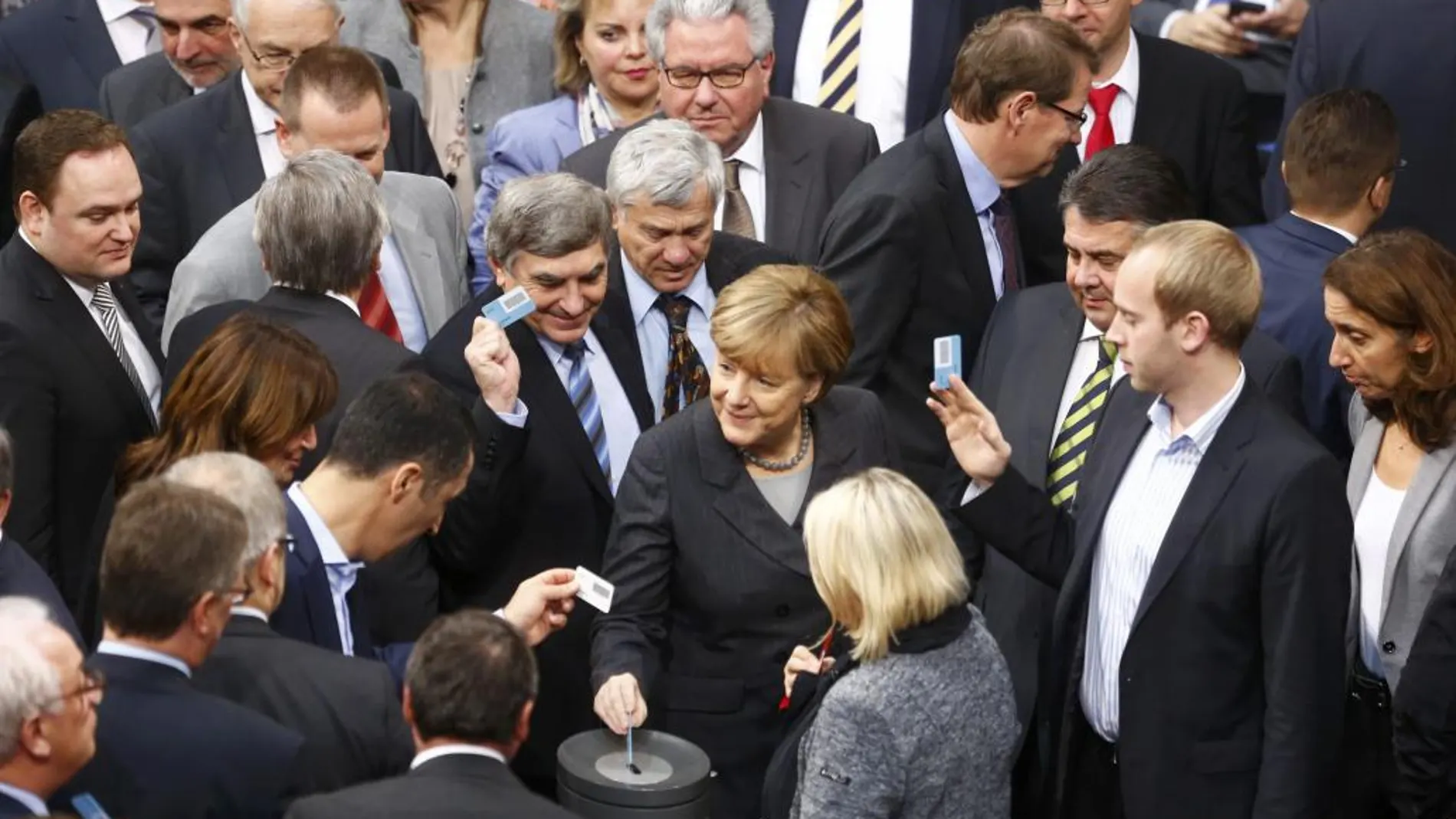 La canciller, Angela Merkel, deposita su voto durante la sesión en el Bundestag.