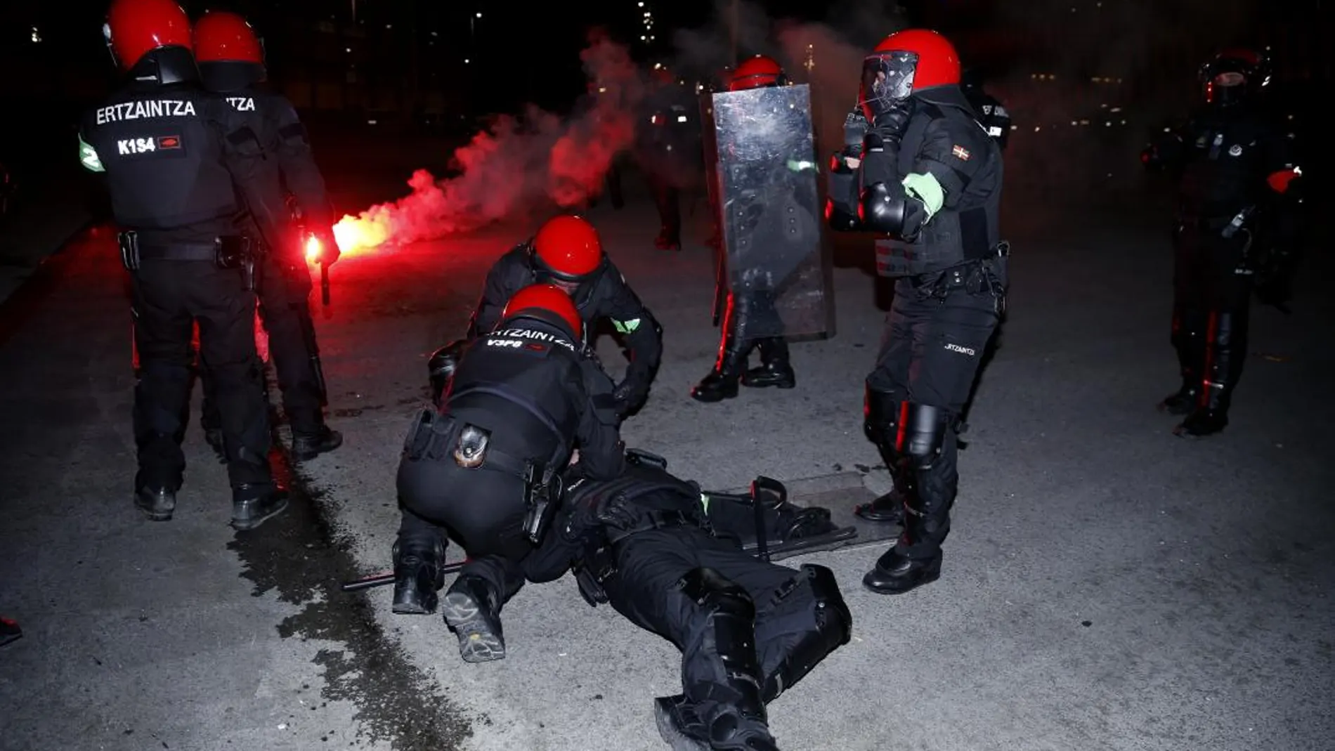 Agentes de la Ertzaintza atienden a un compañero tras varias cargas con aficionados momentos antes de comenzar el partido entre el Athletic Bilbao- Spartak de Moscú. EFE