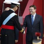 El rey Felipe saluda al presidente de la Generalitat valenciana, Ximo Puig, durante el desfile del Día de la Fiesta Nacional