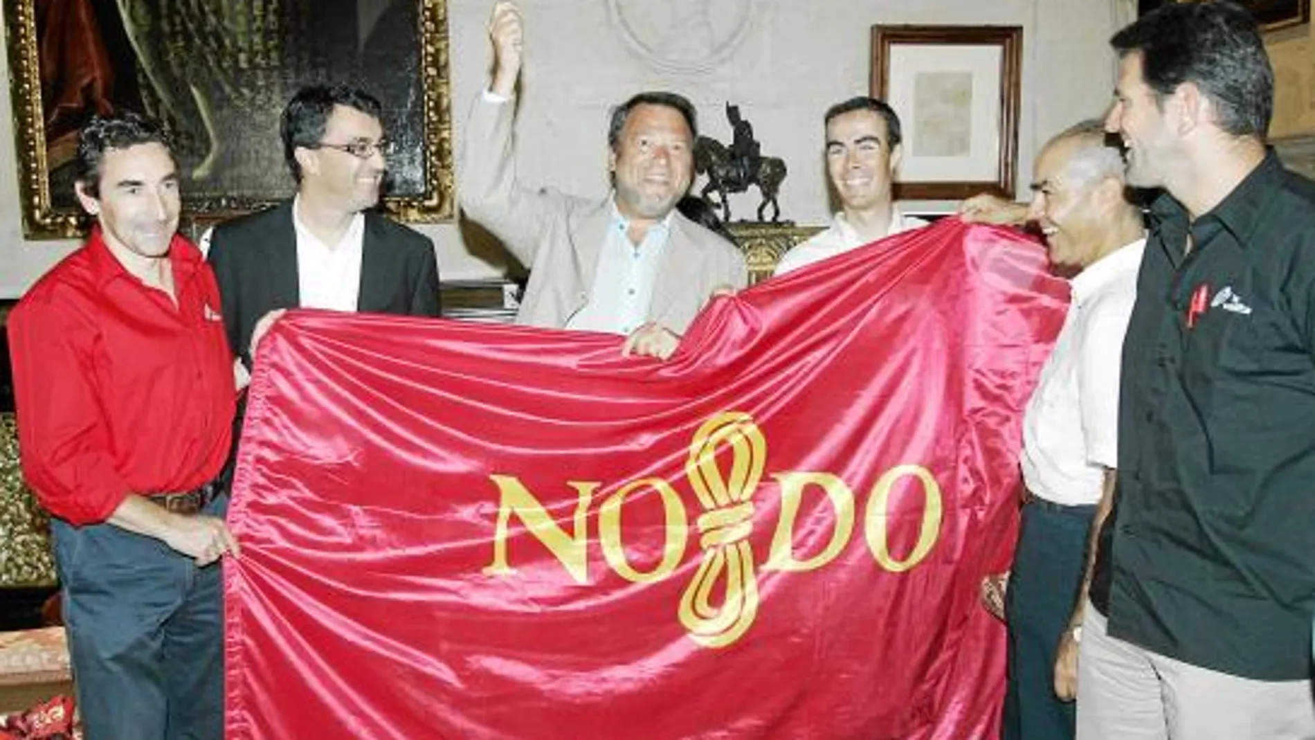 El alcalde bromea al mostrar la bandera de la ciudad que le regaló al ciclista sevillano Antonio Piedra