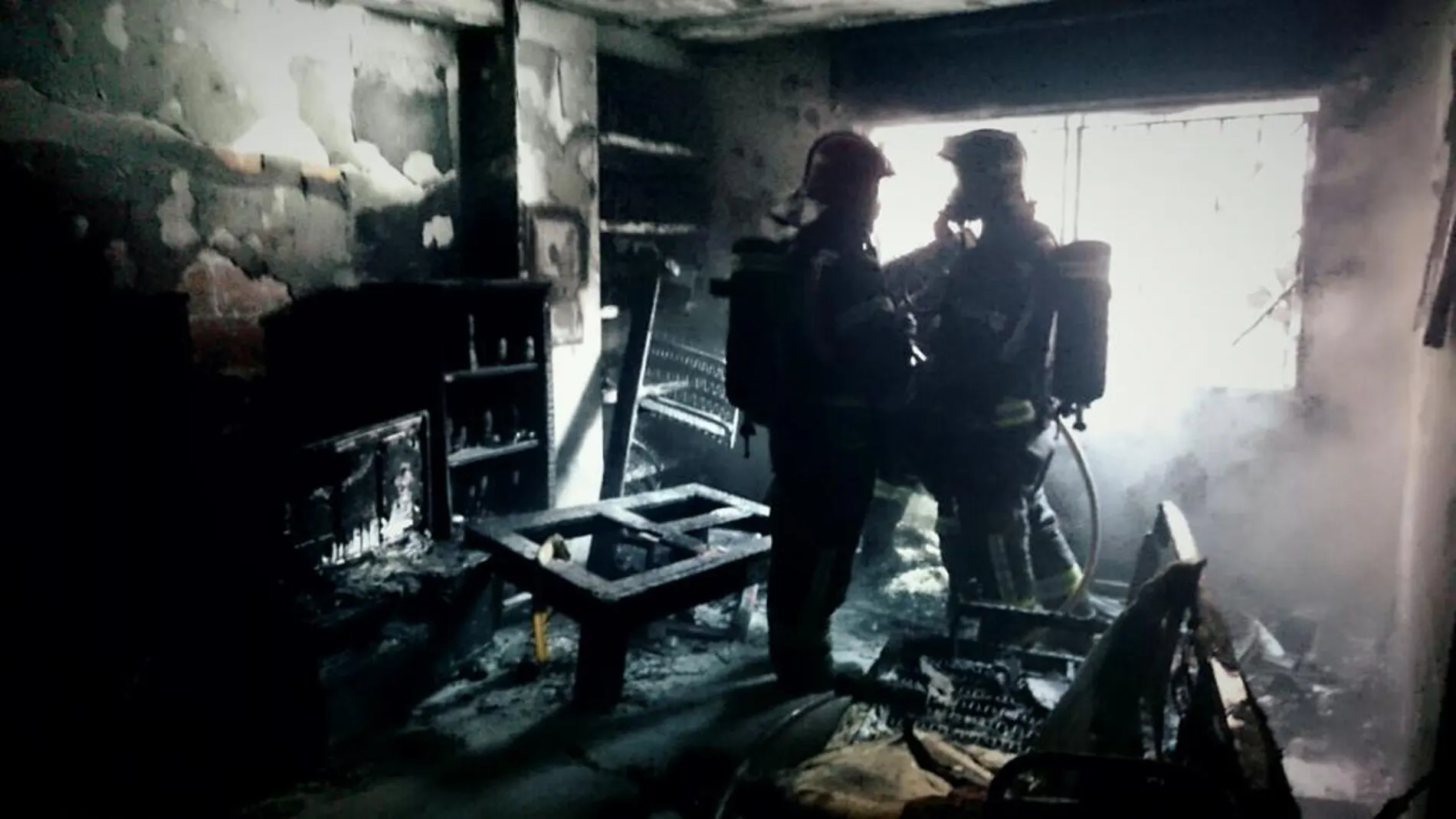 Los bomberos en el interior del piso incendiado