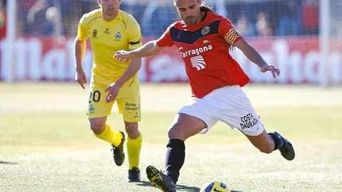 MINGO conduce el balón ante la atenta mirada del centrocampista del Alcorcón Fernando Sales