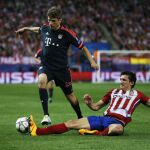 El defensa montenegrino del Atlético de Madrid Stefan Savic (d) lucha el balón con Thomas Muller, del Bayern de Múnich