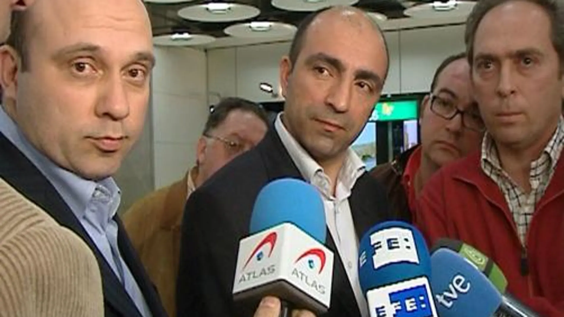 Los forenses turcos Bülent Sam (c) y Omer Müslümanoglu (i), a su llegada al aeropuerto madrileño de Barajas