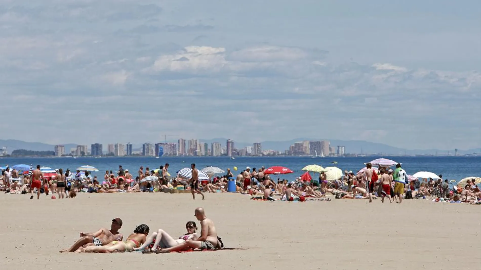 Miles de personas se han acercado a las playa de la ciudad de Valencia para disfrutar del intenso sol y la altas temperaturas en esta jornada