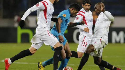 Los jugadores del Sevilla (i-d) Vicente Iborra, Ever Banega y Stephane Mbia tratan de frenar la internada de Hulk (2-i), del Zenit de San Petersburgo, durante el partido de vuelta de los cuartos de final de la Liga Europa
