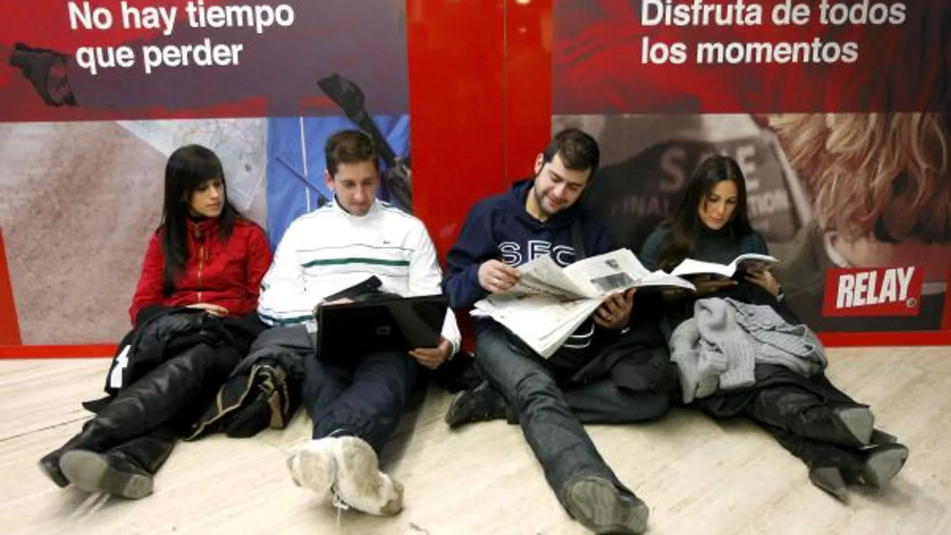 Tres jóvenes esperan su vuelo hoy en el aeropuerto de Sevilla