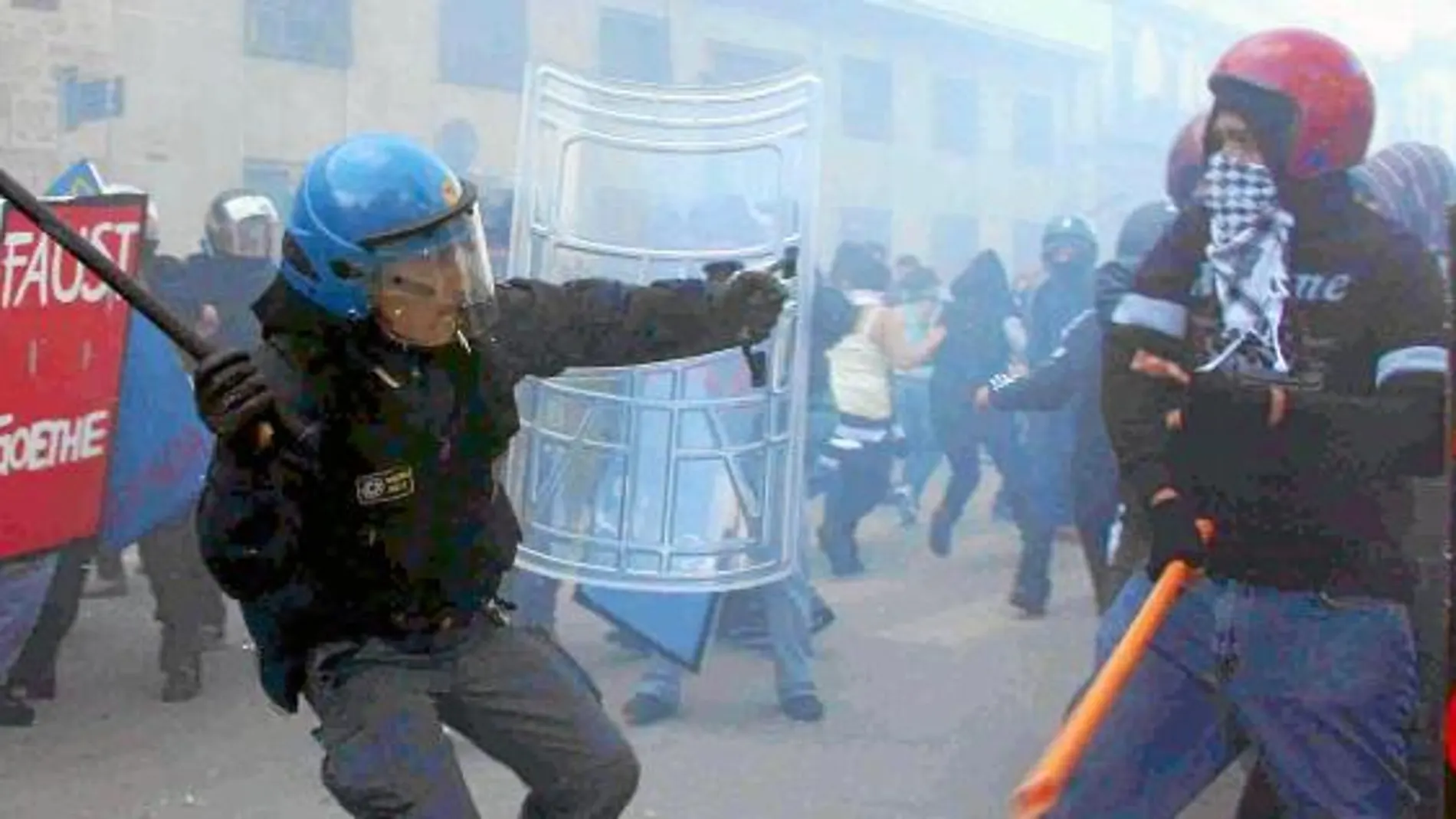 Un Policía se enfrenta a varios encapuchados, ayer, en Palermo