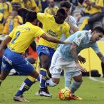 El centrocampista ghanés de la UD Las Palmas, Wakaso Mubarak y su compañero David Simón pelean un balón con el defensa argentino del Celta de Vigo Gustavo Cabral