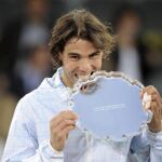 El tenista español Rafa Nadal muerde el trofeo tras ganar al suizo Roger Federer