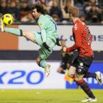 Messi captura un balón ante la presencia del jugador osasunista Sergio Fernández. El argentino dio el pase del primer gol anoche y marcó dos