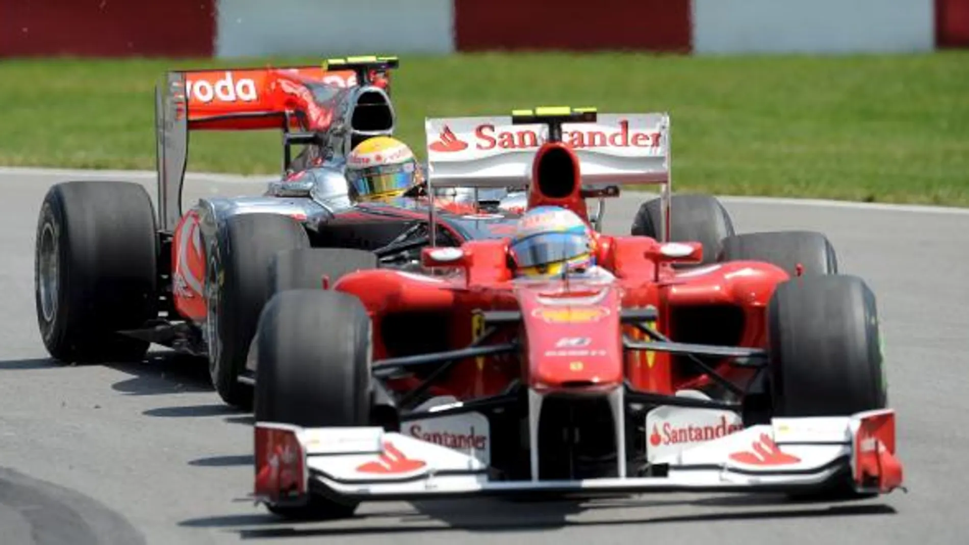 El piloto español Fernando Alonso de Ferrari (delante) conduce su monoplaza junto al británico Lewis Hamilton de McLaren Mercedes, (detrás), durante el Gran Premio de Canadá