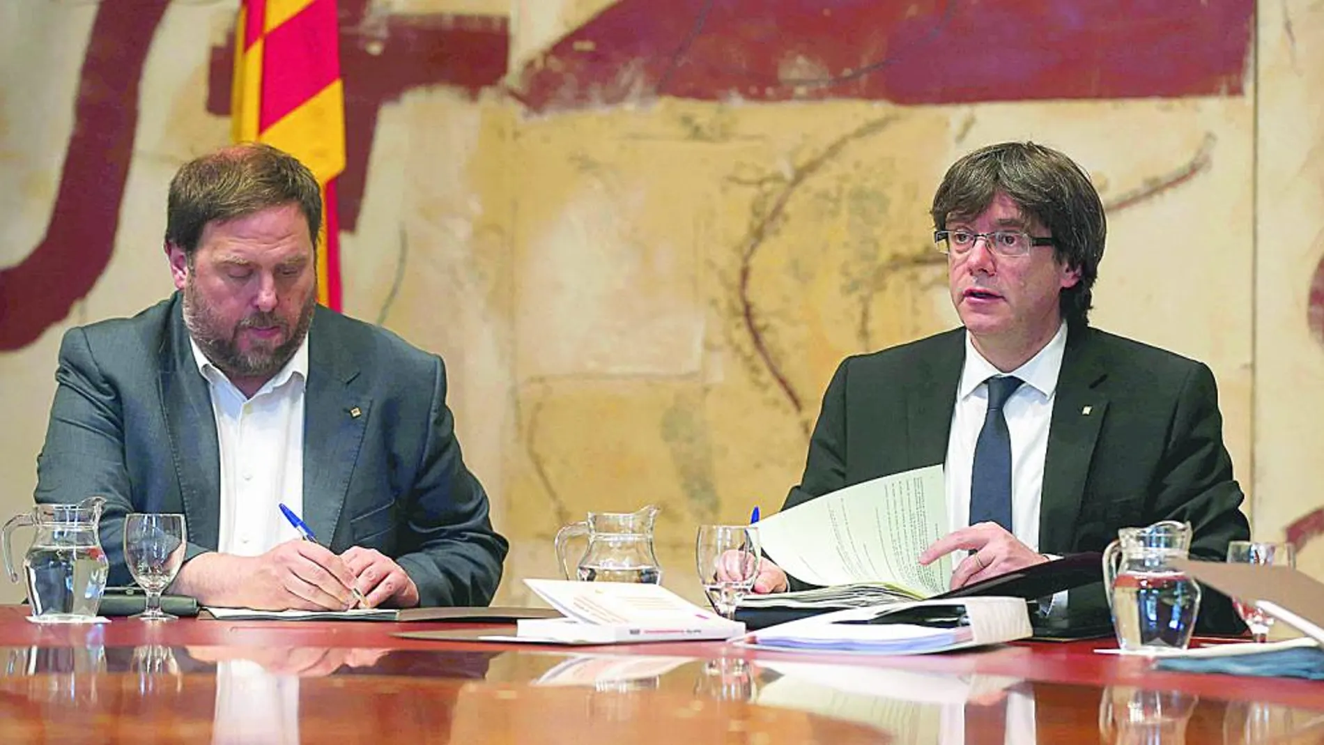 El presidente de la Generalitat, Carles Puigdemont (d), y su vicepresidente y conseller de Economía, Oriol Junqueras, durante la reunión semanal del gobierno catalán
