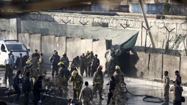Bomberos trabajan en el lugar donde fue perpetrado un ataque suicida, cerca de un cuartel de la Policía en Kabul