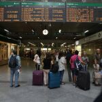 Viajeros miran los horarios en la estación madrileña de Atocha en la primera de las jornadas de huelga