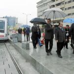El secretario de Estado, Gaspar Zarrías; el senador Juan Espadas, con paraguas; y el edil de Movilidad, Francisco Fernández, desprotegido