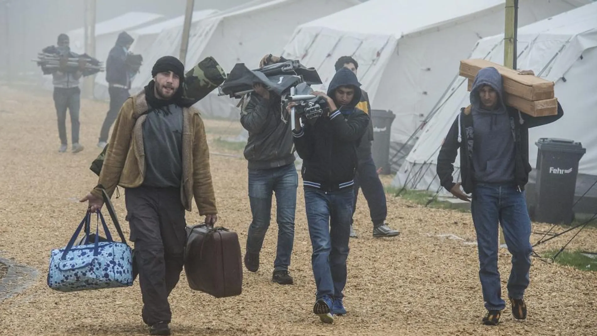 Refugiados trasladan sus pertenencias al abandonar un refugio temporal. EFE/Boris Roessler
