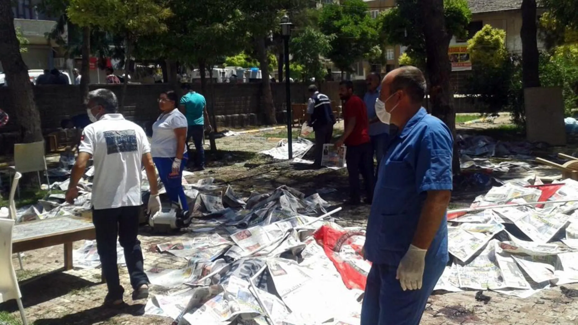 Varios cuerpos cubiertos con papeles de periódicos tras producirse la explosión de un artefacto en un centro cultural en Suruc, provincia de Sanliurfa (Turquía)