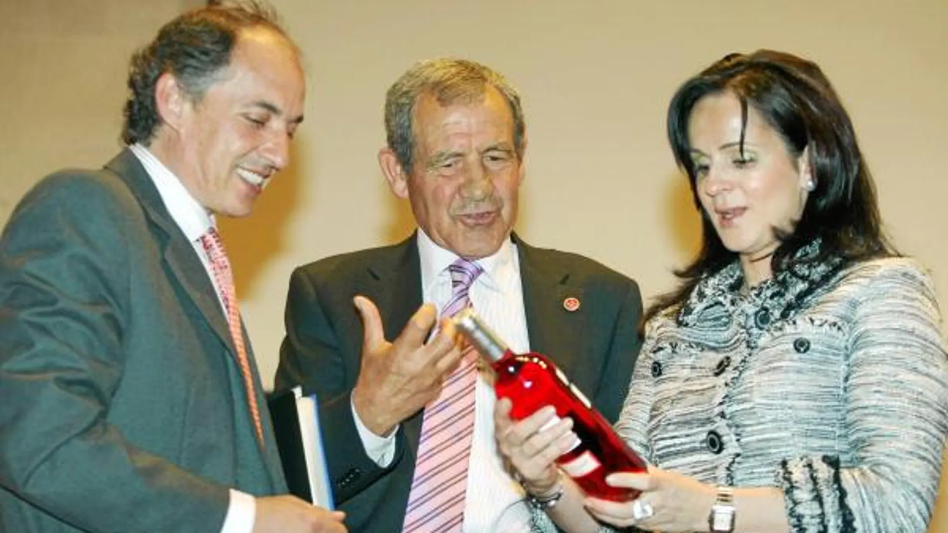 La consejera escucha las explicaciones de Gabriel Alonso, presidente de Urcacyl, sobre uno de los vinos ganadores