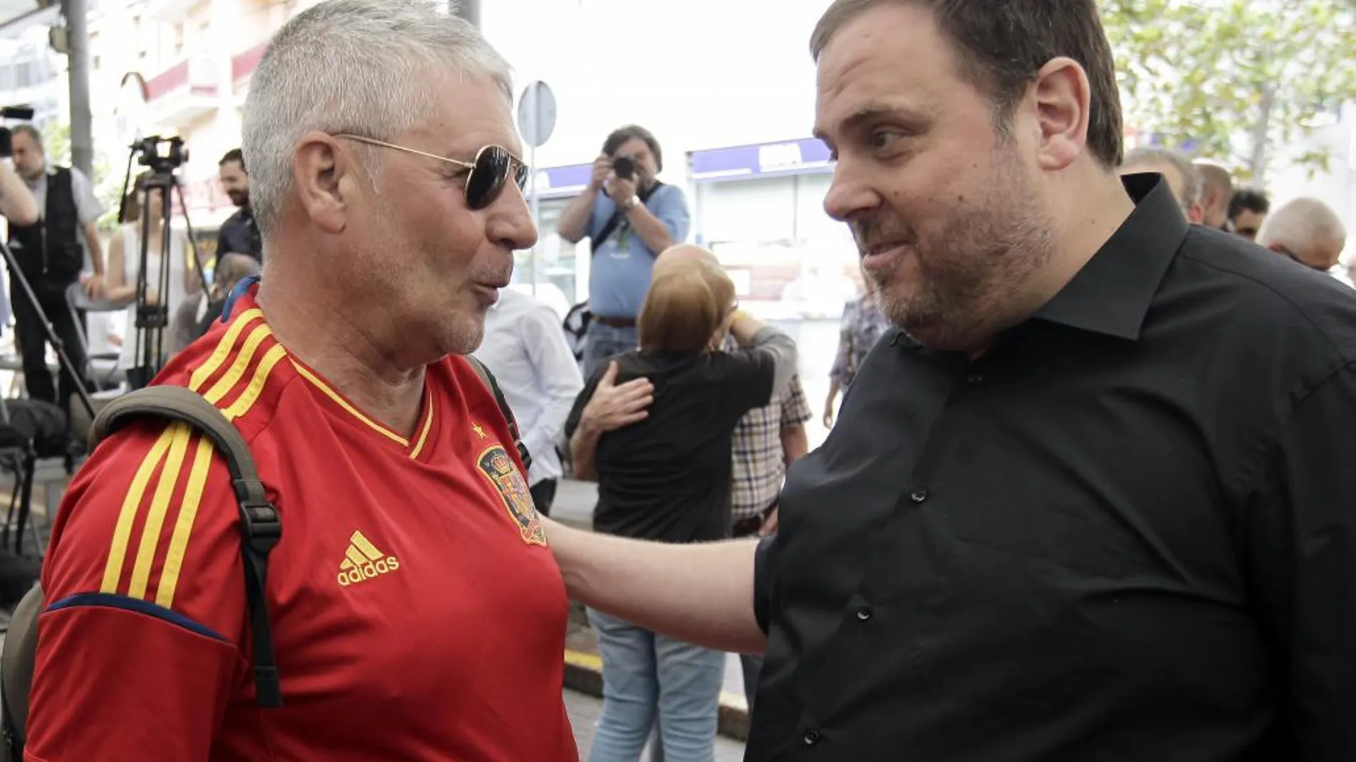 El presidente de ERC y vicepresidente de la Generalitat, Oriol Junqueras, saluda a un simpatizante que va vestido con una camiseta de la selección española de fútbol, poco antes del mitin en Nou Barris