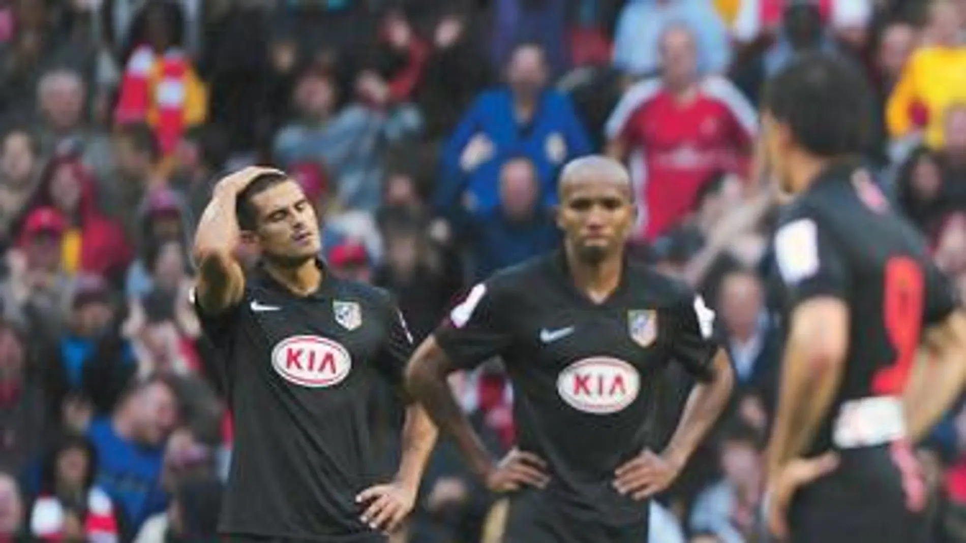 Juanito y Assunçao se lamentan después del segundo gol del Arsenal