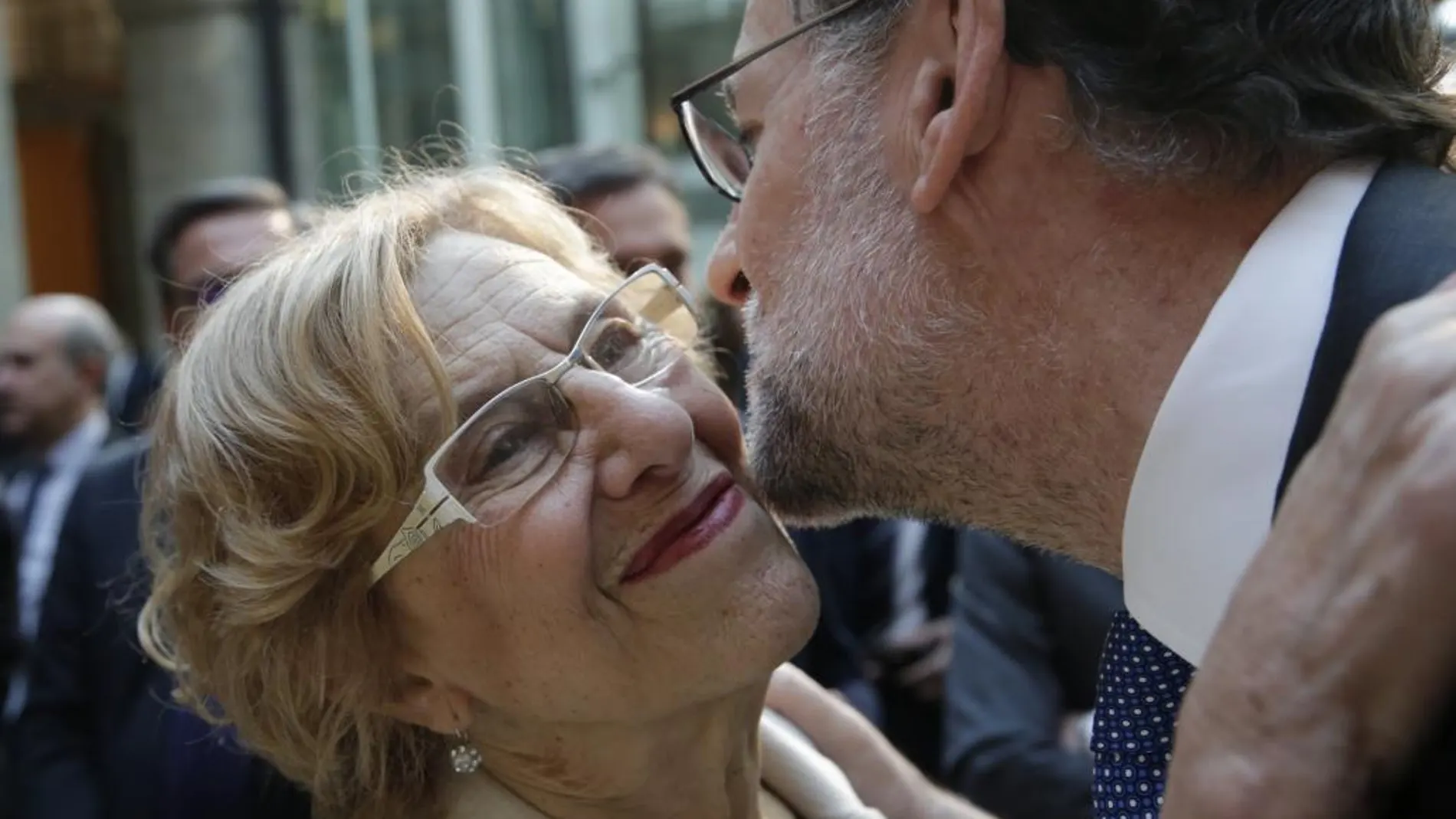 El presidente del Gobierno en funciones, Mariano Rajoy (d), saluda a la alcaldesa de Madrid, Manuela Carmena, a su llegada al acto de imposición de Medallas y Condecoraciones de la Orden del Dos de Mayo, con motivo del Día de la Comunidad de Madrid.