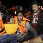 Los servicios de emergencias ayudan a los refugiados llegados en un bote a Lesbos (Grecia).