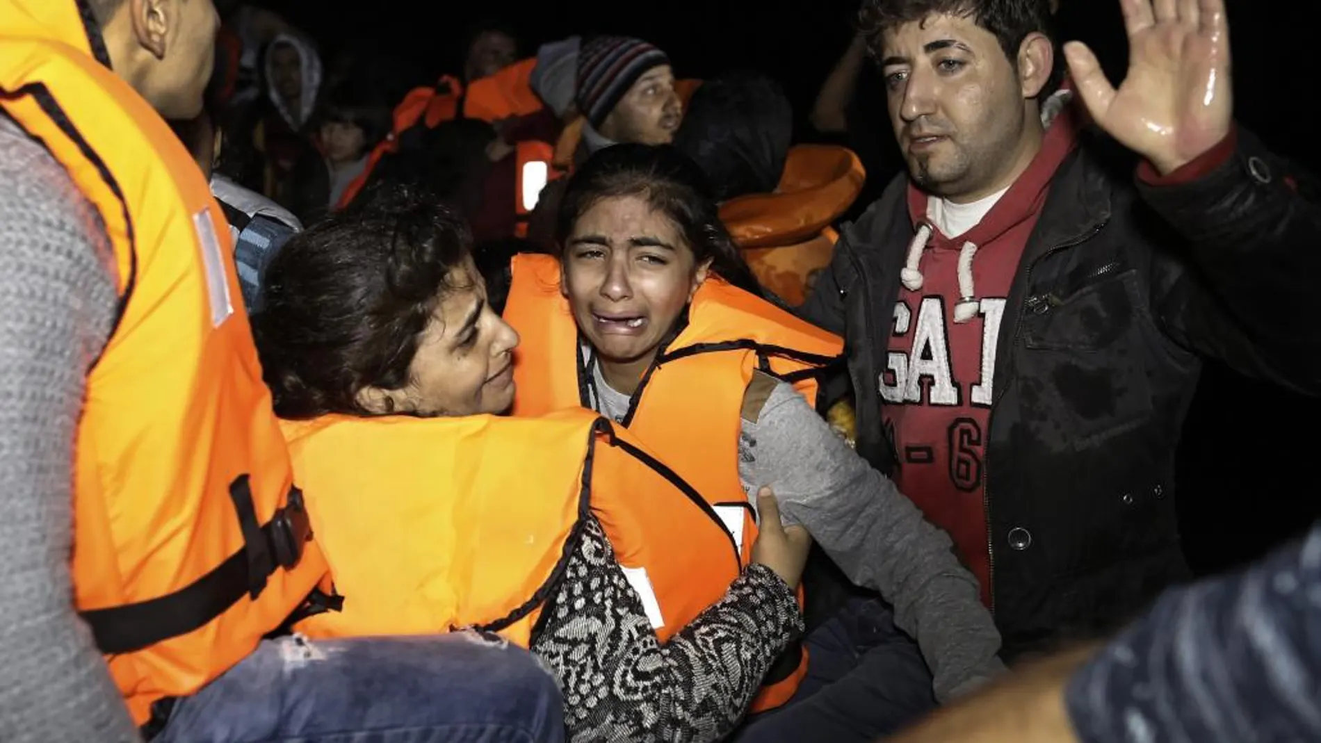 Los servicios de emergencias ayudan a los refugiados llegados en un bote a Lesbos (Grecia).