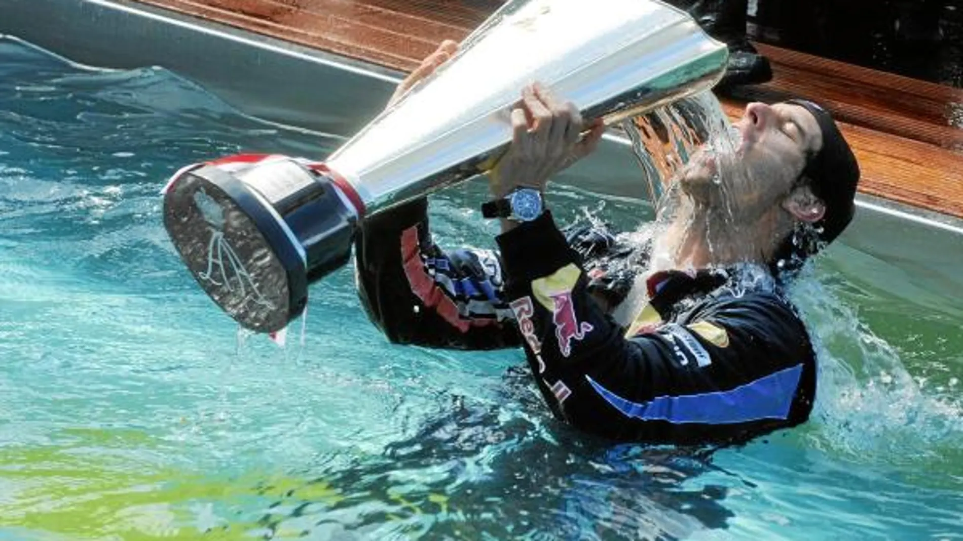 Mark Webber, se moja en la piscina, con el trofeo de ganador en el circuito de Montecarlo