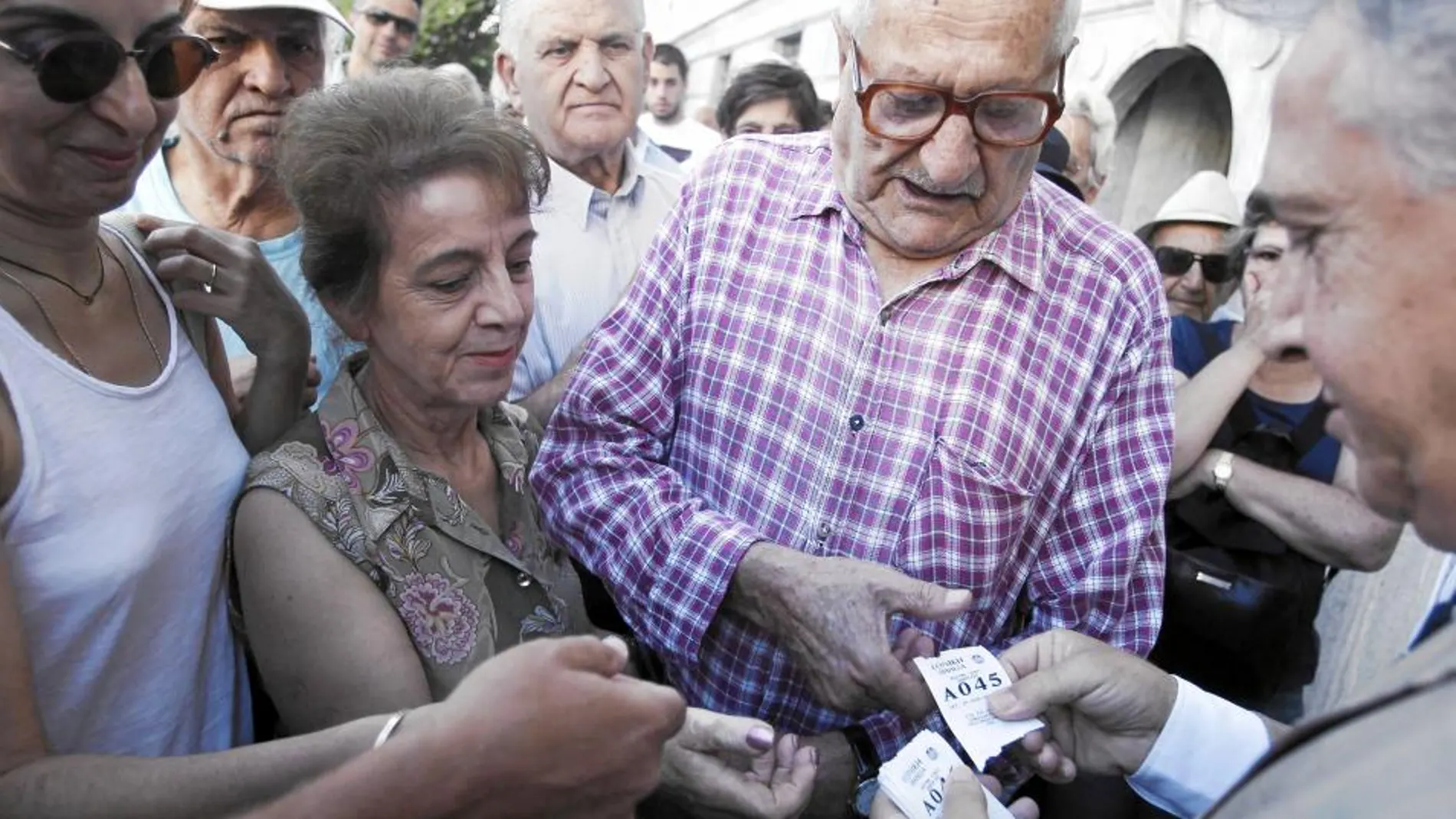 Pensionistas hacen fila para conseguir su turno frente al Banco Nacional de Grecia