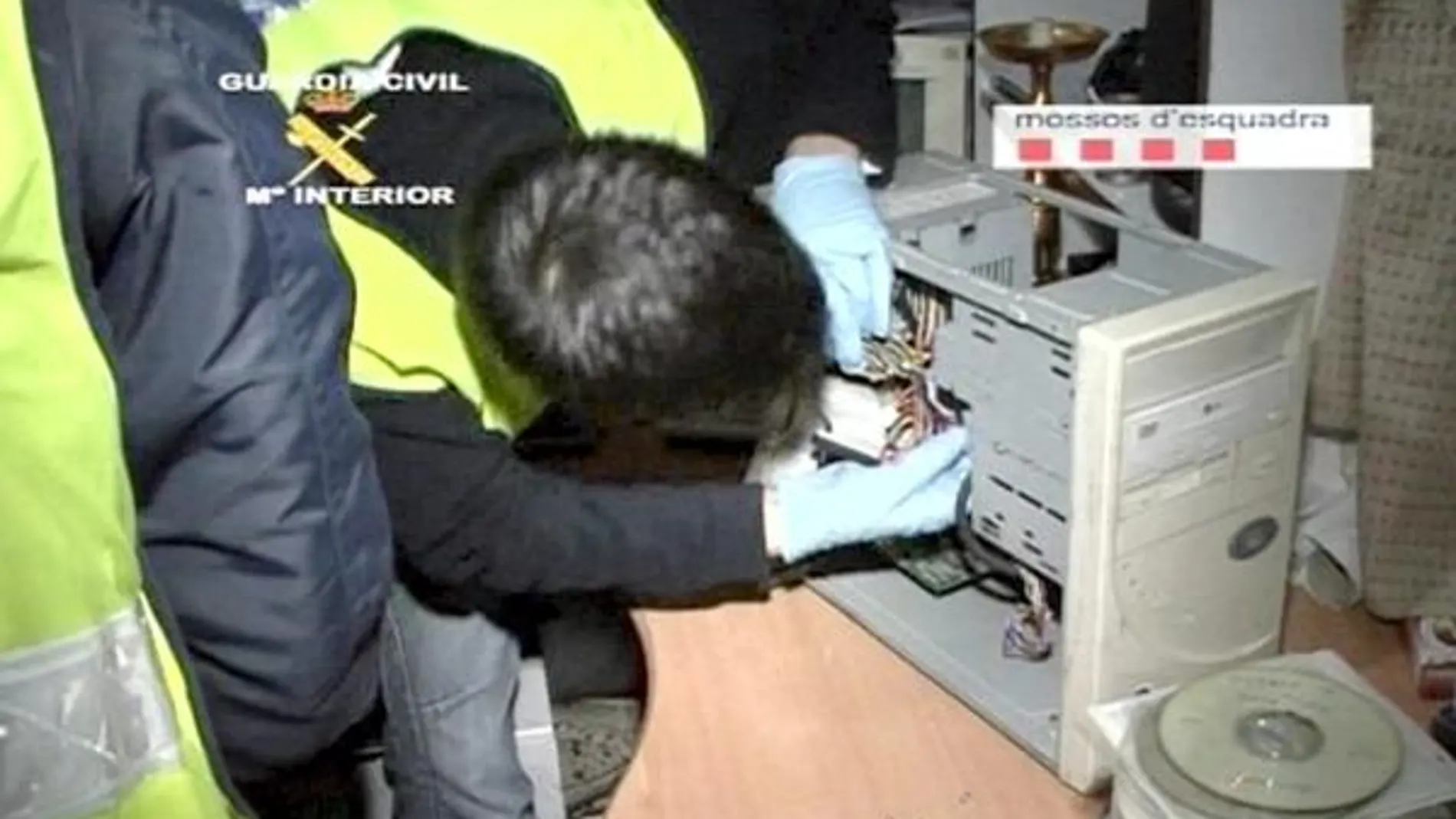 Un agente intenta extraer el disco duro de uno de los equipos incautados para su posterior análisis