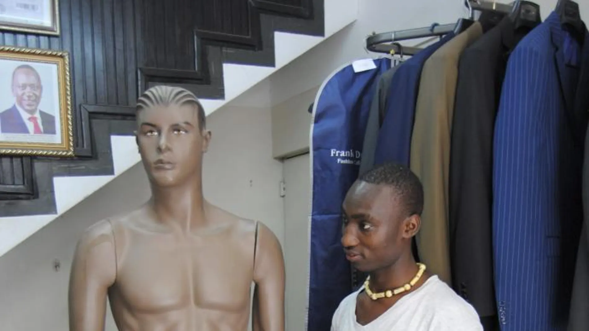 Kelvin Omondi (d), trabajador de la céntrica tienda Kings Castle de Nairobi, posa junto un maniquí desnudo que luce un caparazón metálico que encierra sus genitales bajo llave.