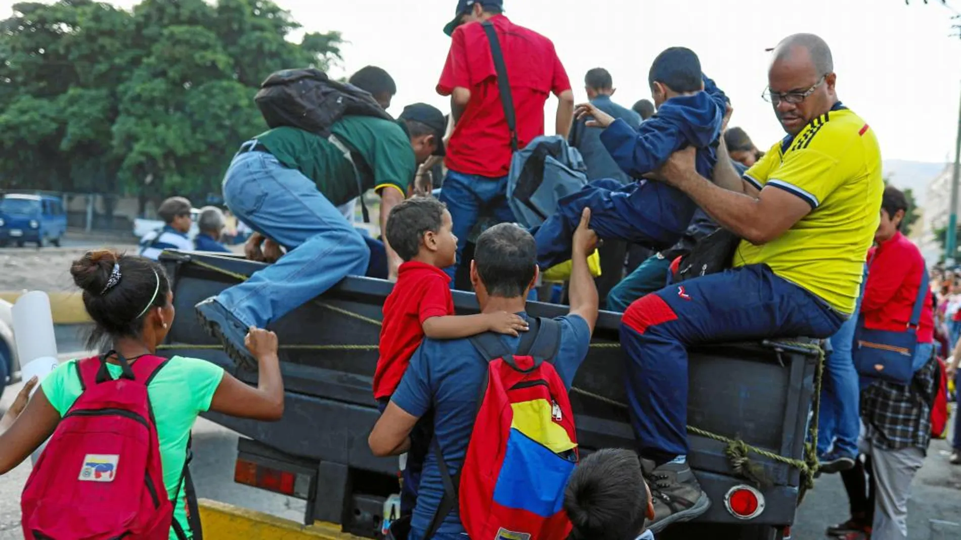 Venezolanos se suben a un camión que hace las veces de autobús ante la falta de medios de transporte públicos en Caracas