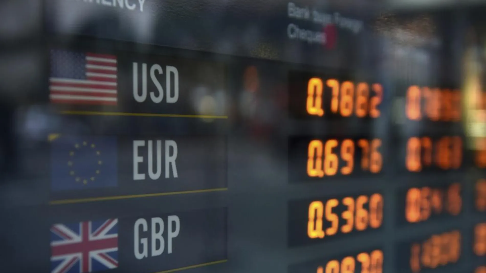Un panel informa de los tipos de cambio del dólar, euro y la libra esterlina, en Sídney, Australia